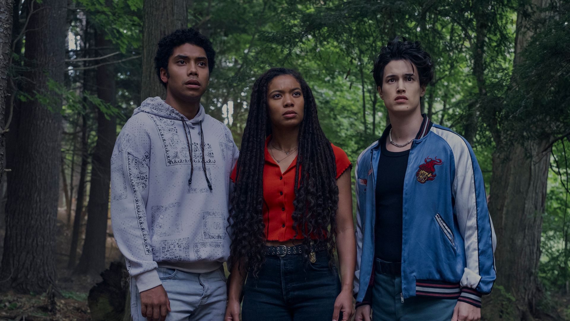 three teens standing in woodland