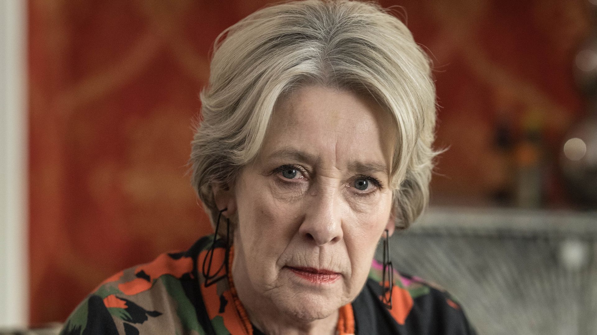 woman dressed in colourful jacket sitting on chair