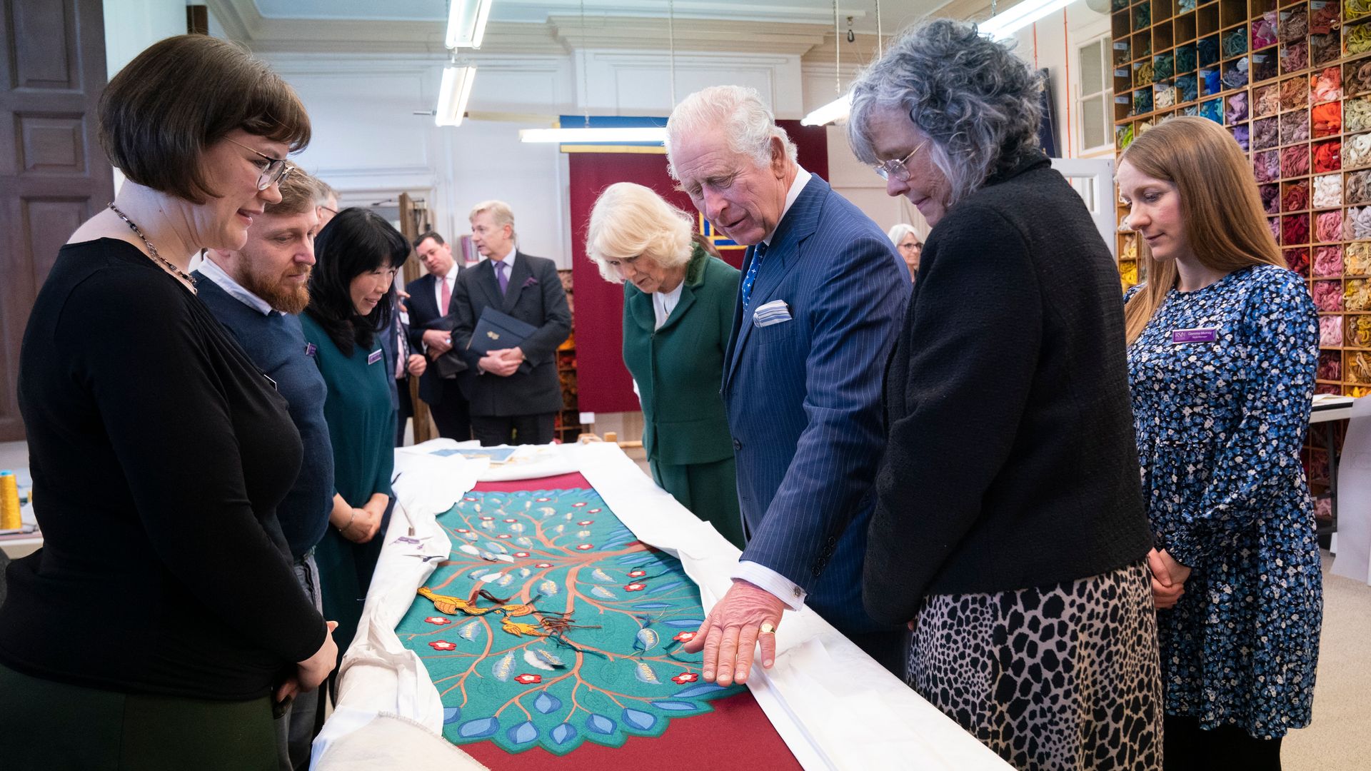 King Charles III and the Queen Consort look at the needlework on part of the Anointing Screen