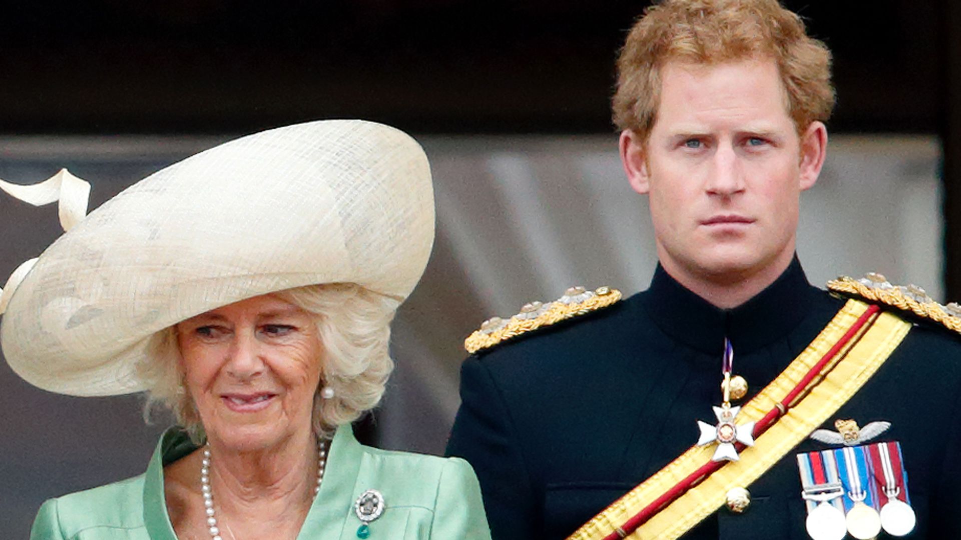 Queen Camilla in a green coat and Prince Harry in his black military uniform