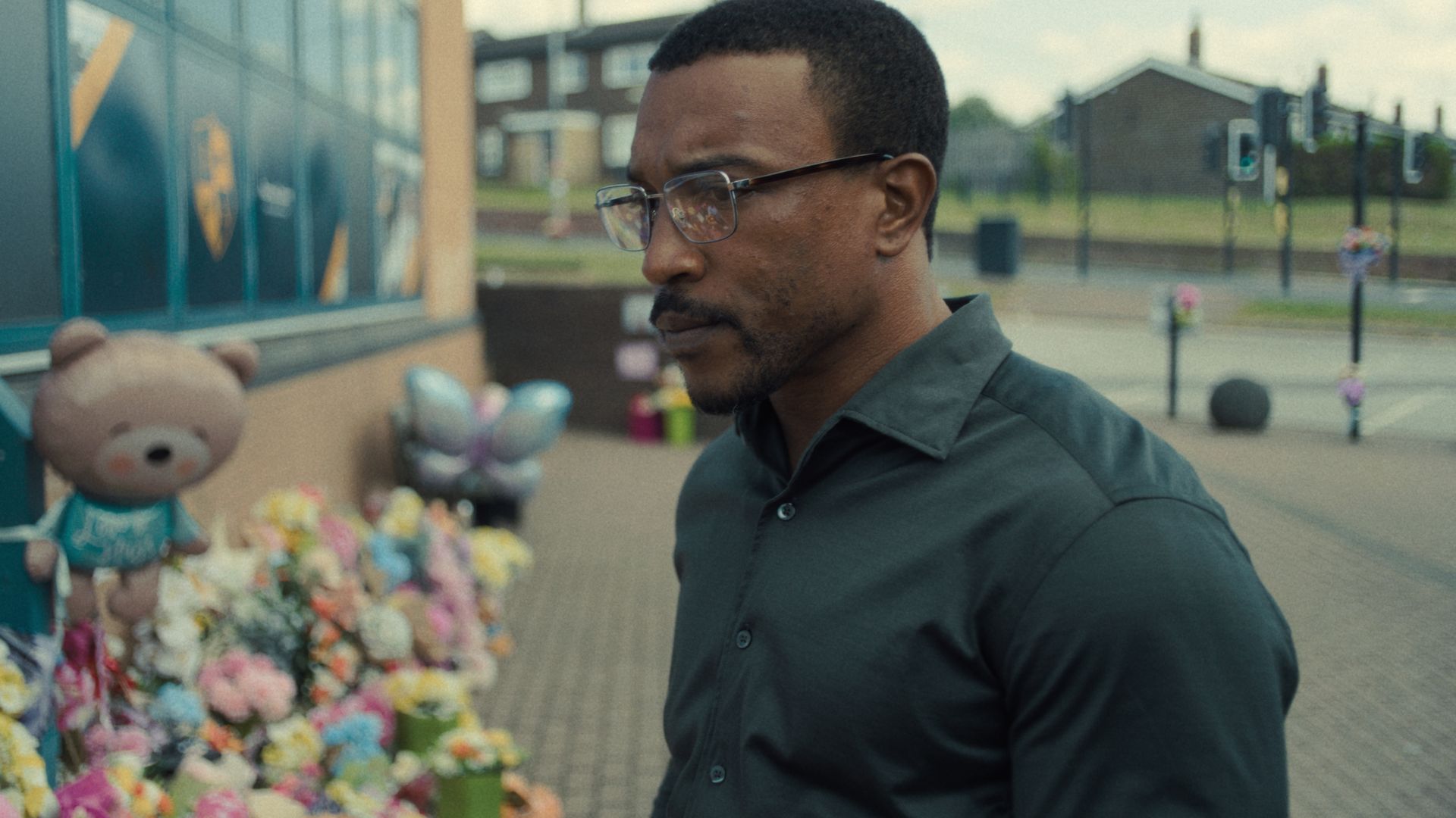 Ashley Walters in Adolescence looking at tributes