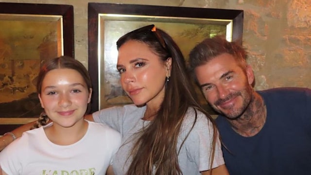 Harper Beckham wearing a 'J'adore Dior' T-shirt as she poses with Victoria and David Beckham