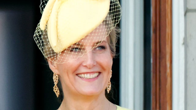 Sophie, Duchess of Edinburgh smiling in yellow beside Queen Camilla