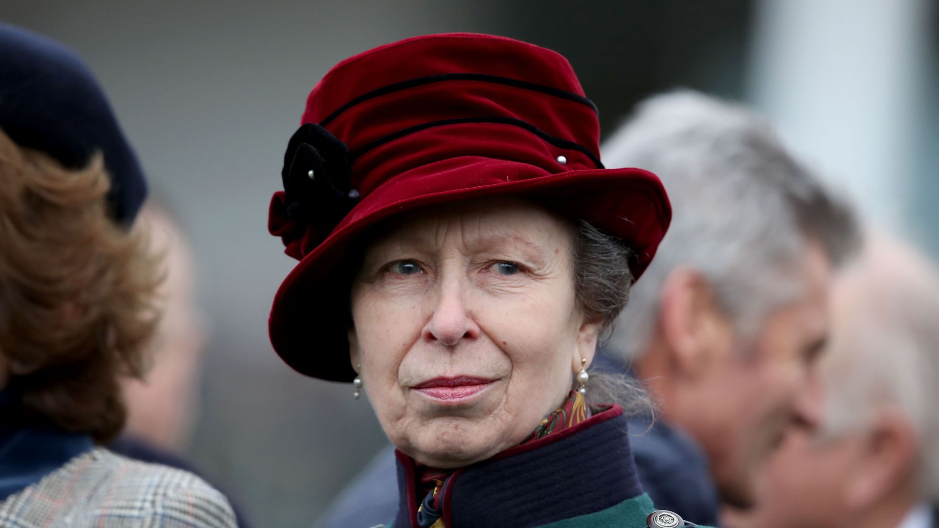 close-up woman in green jacket and red hat