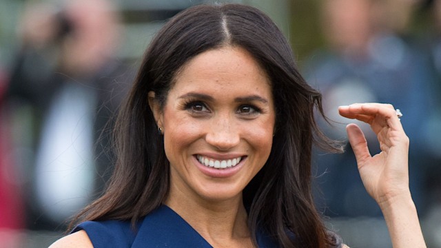Meghan, Duchess of Sussex smiling in teal dress 