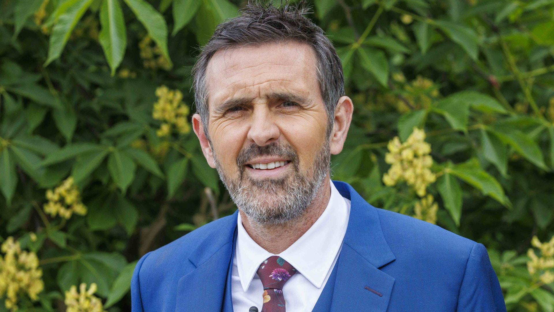 Adam Frost in a blue suit at the chelsea flower show 