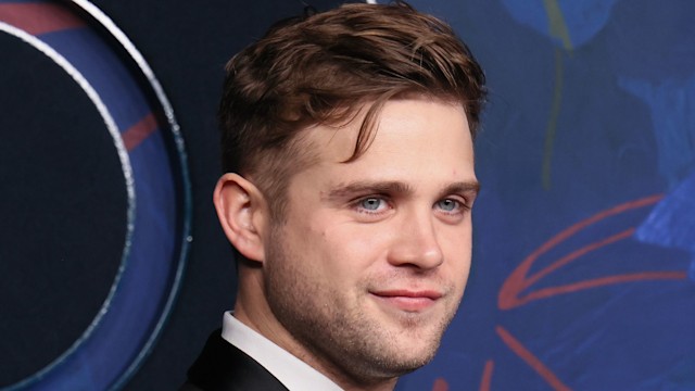 actor posing at reception in suit