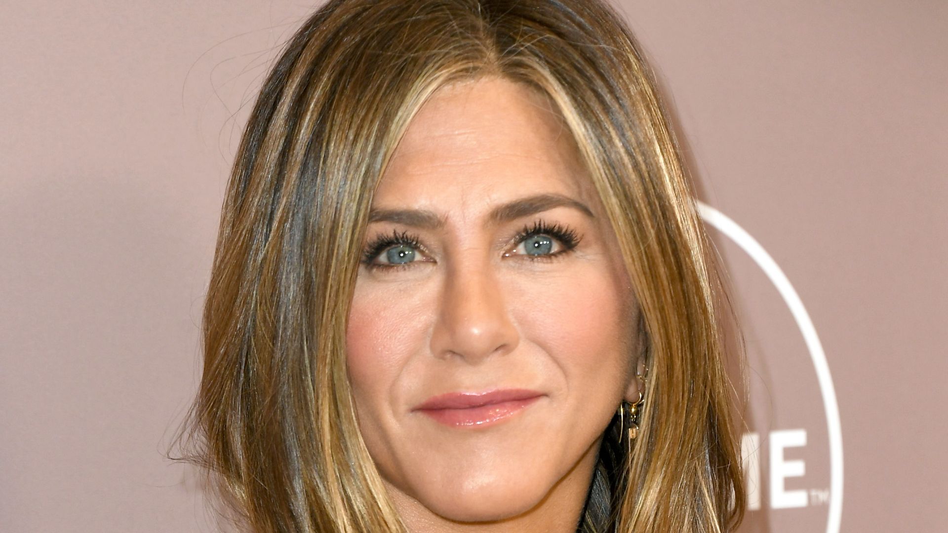 Jennifer Aniston straight faced in dark striped dress