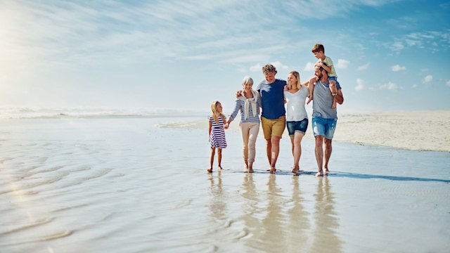 Shot of a happy family going for a walk together at the beach