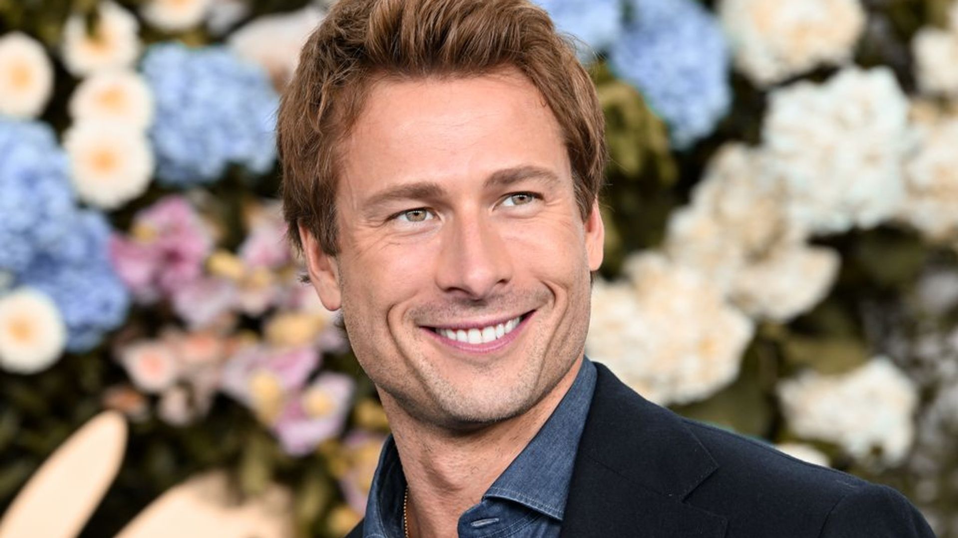 Glen Powell poses on red carpet