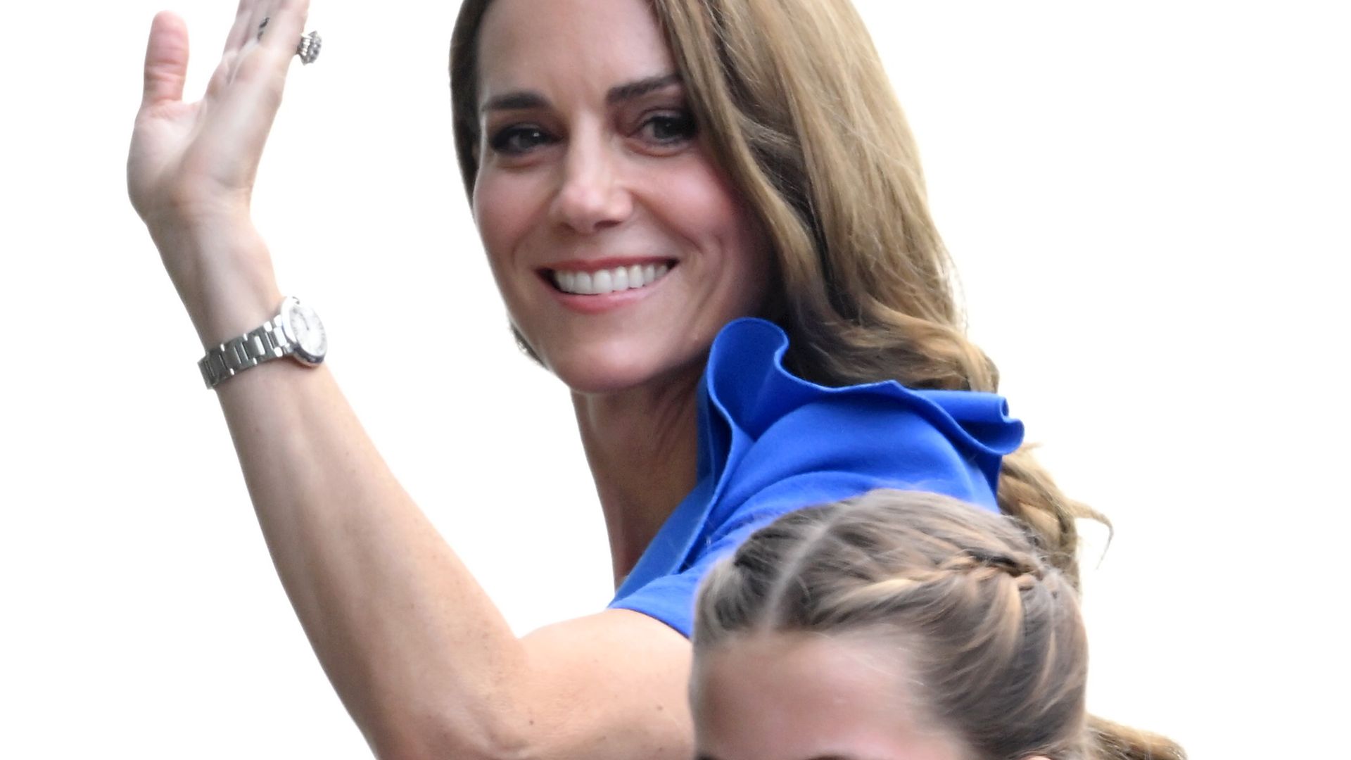 Kate Middleton and Princess Charlotte walking across a bridge and waving