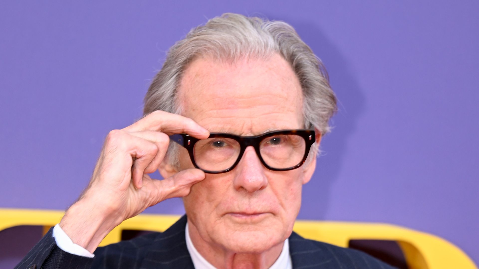 Bill Nighy with glasses and suit 