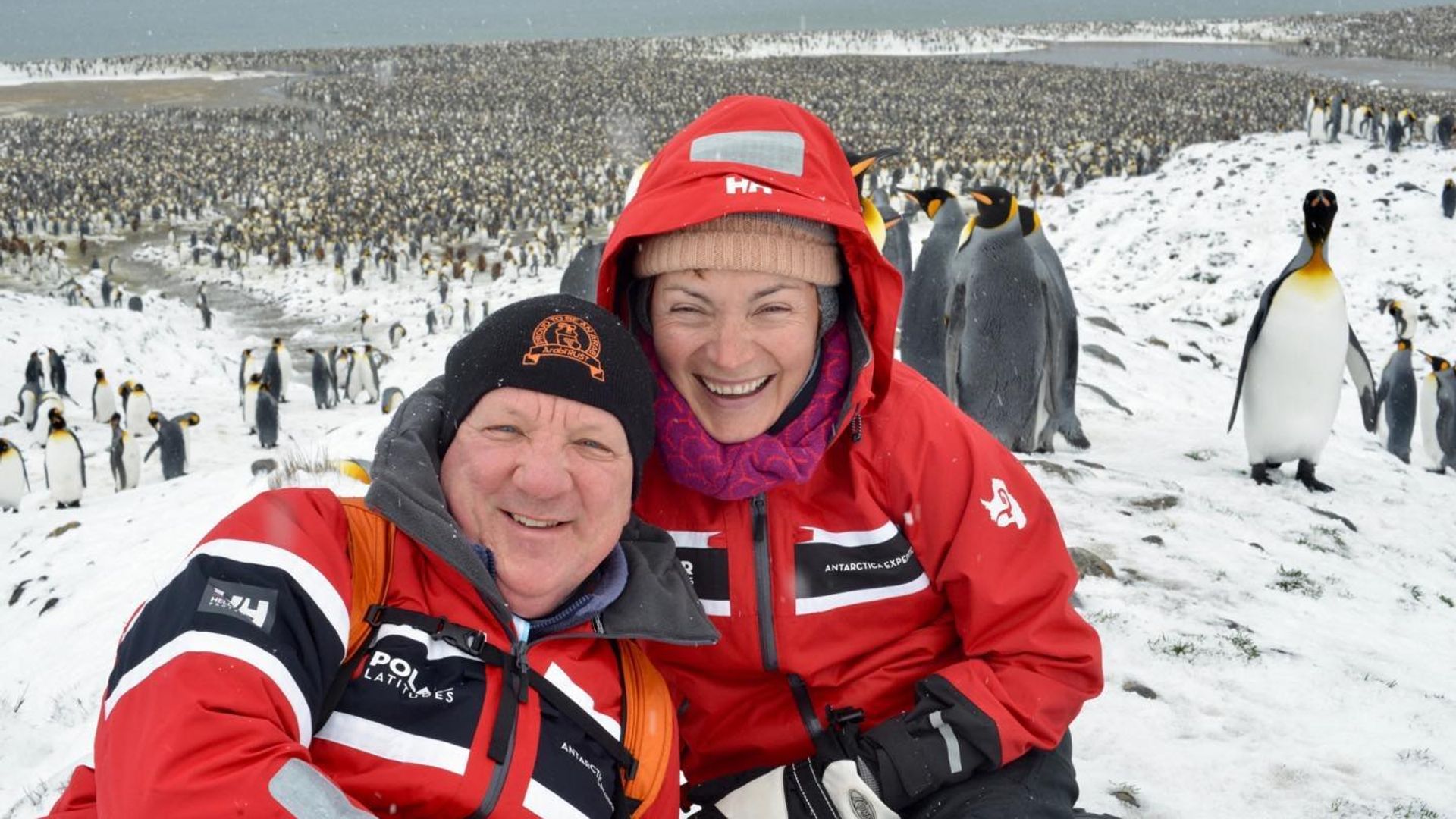 couple posing with penguins