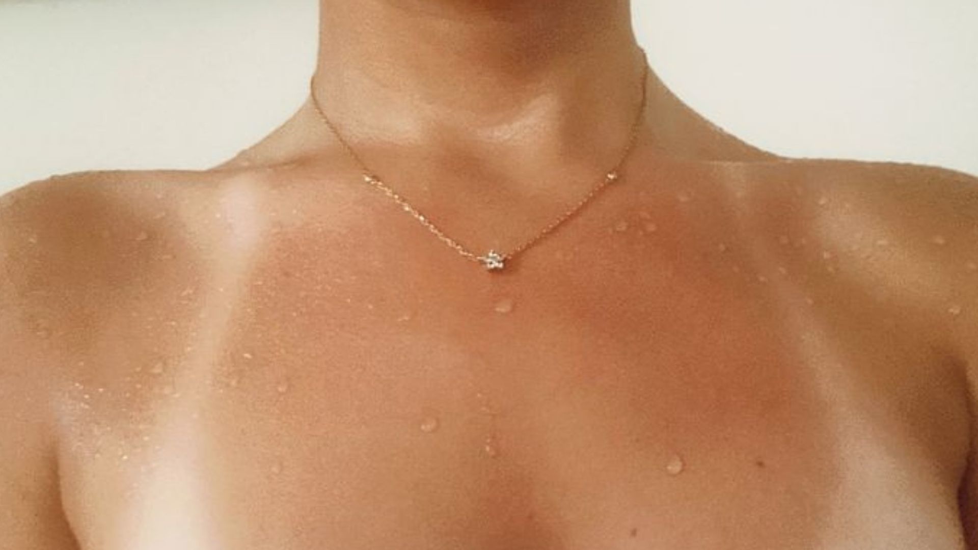 woman's neck and collarbone with tan lines wearing a towel