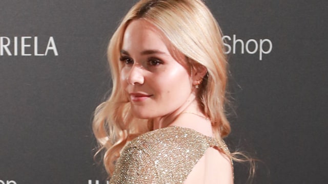 Holly Ramsay in a sparkly backless dress with blonde curly hair