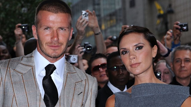 David Beckham in a suit and Victoria Beckham in a grey dress