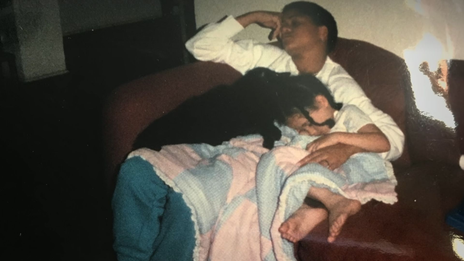 A young Meghan Markle and Doria Rafland sleeping on a sofa