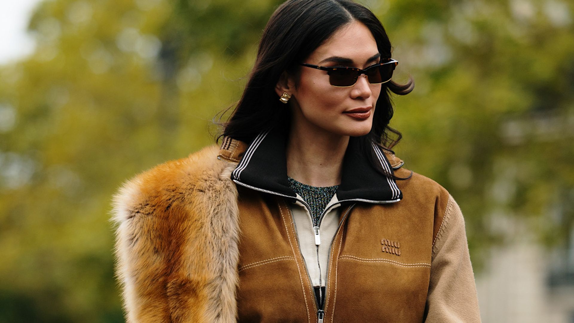 model in miu miu look with sunglasses and tan suede jacket with fur stole
