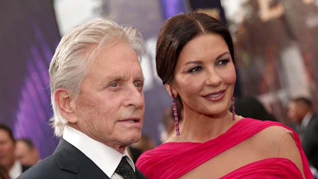 Catherine Zeta-Jones wearing a pink gown and Michael Douglas in a suit at a red carpet event