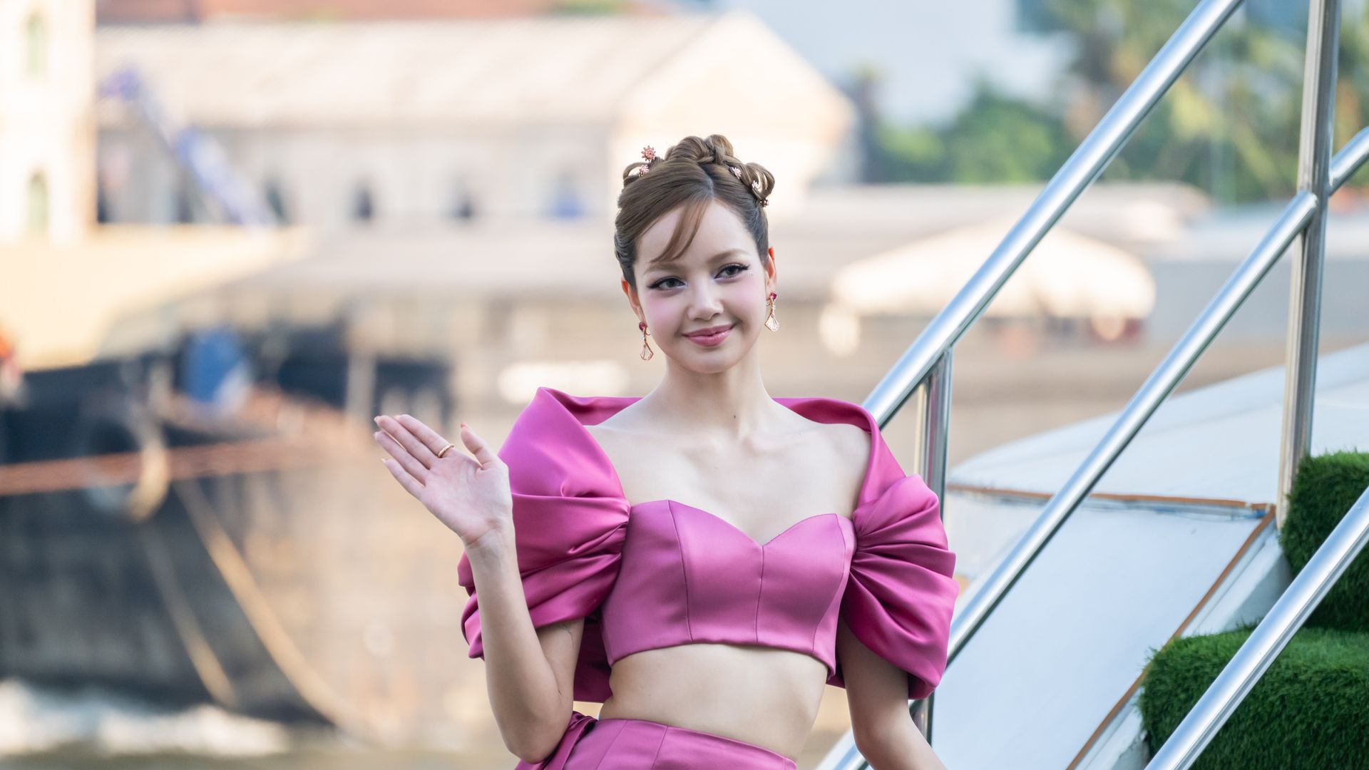 Lisa in a vibrant pink structured two-piece outfit with puff sleeves