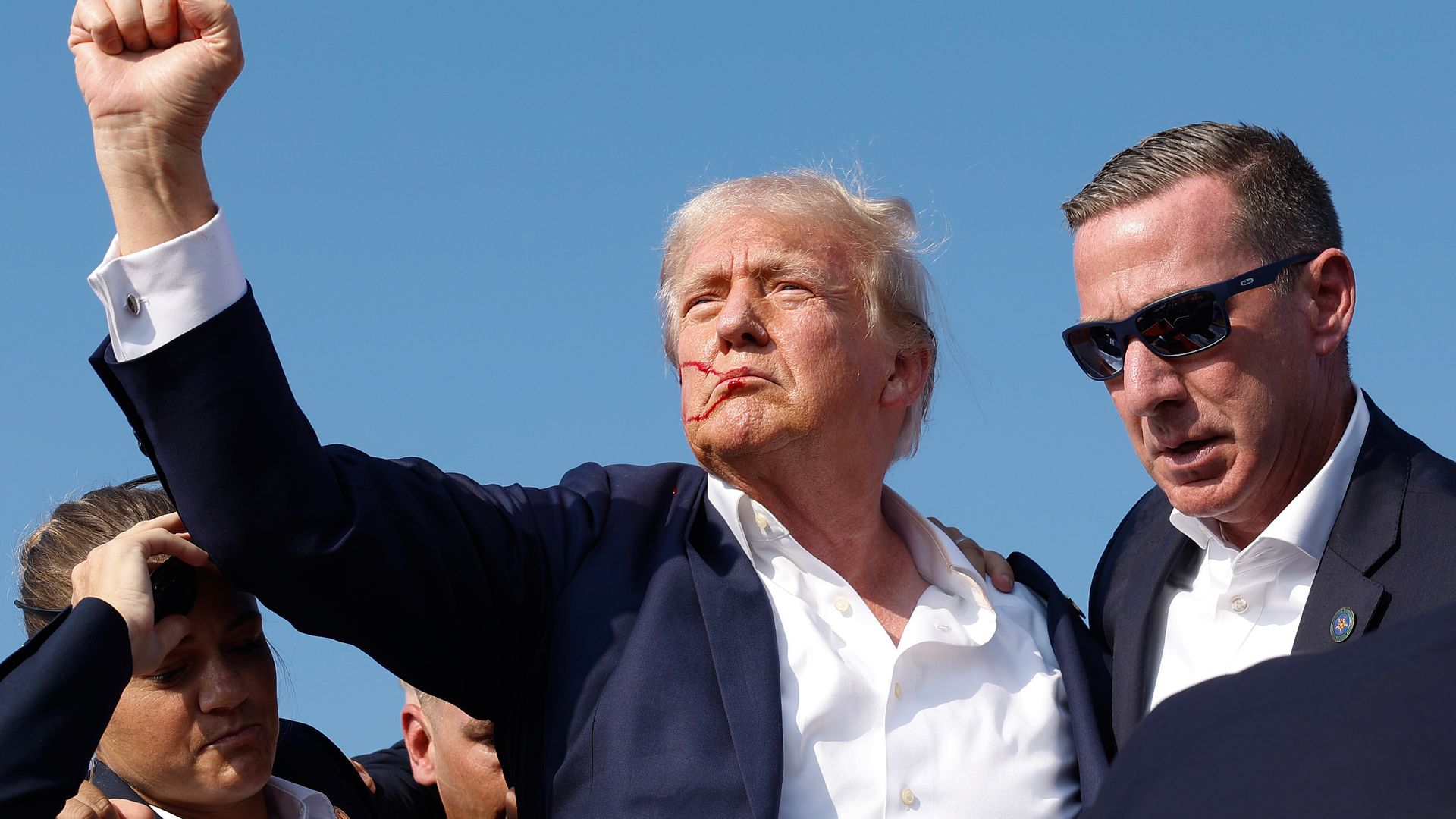 Republican presidential candidate former President Donald Trump pumps his fist as he is rushed offstage during a rally on July 13, 2024 in Butler, Pennsylvania