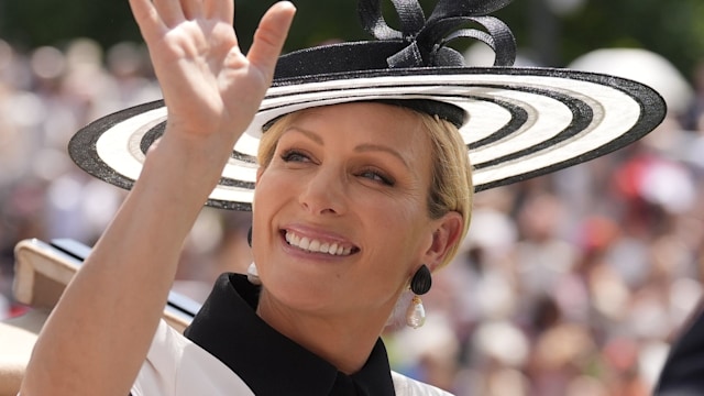 Zara Tindall waving from carriage in black and white dress and hat