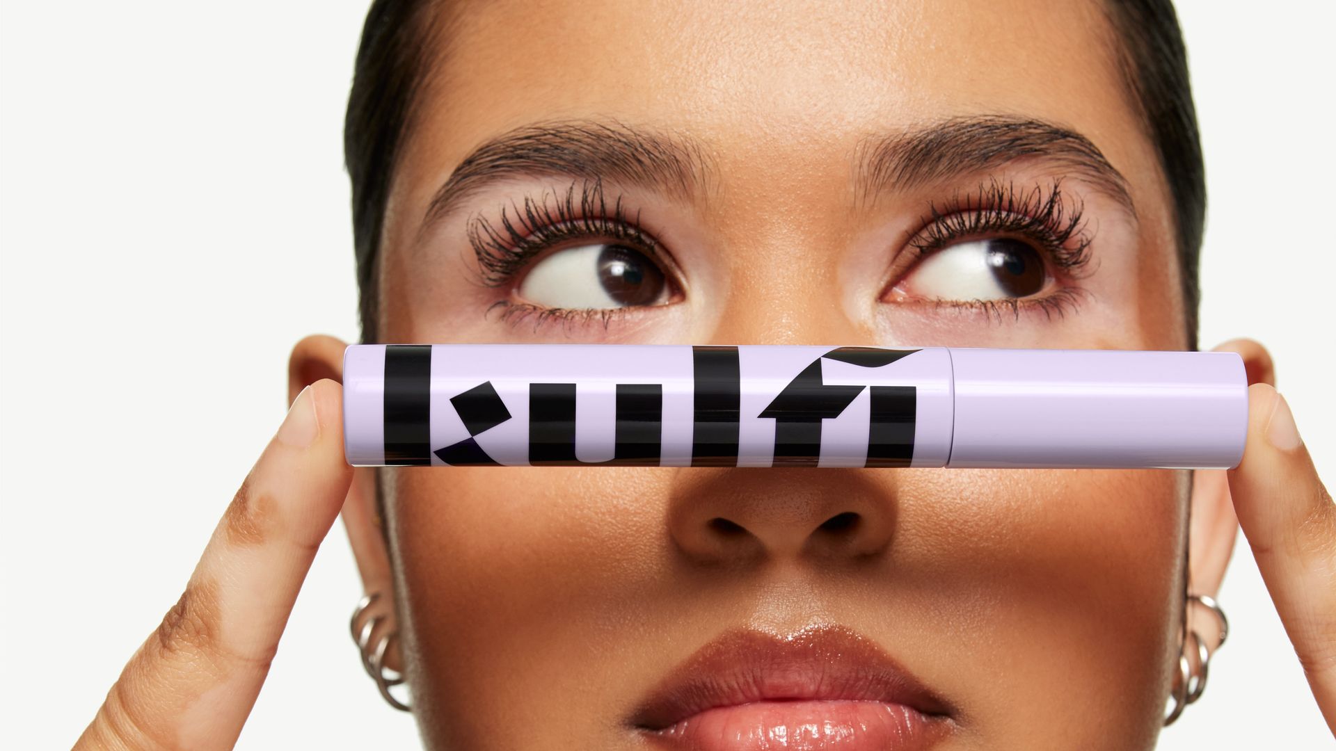 A woman holding a purple Kulfi Beauty mascara