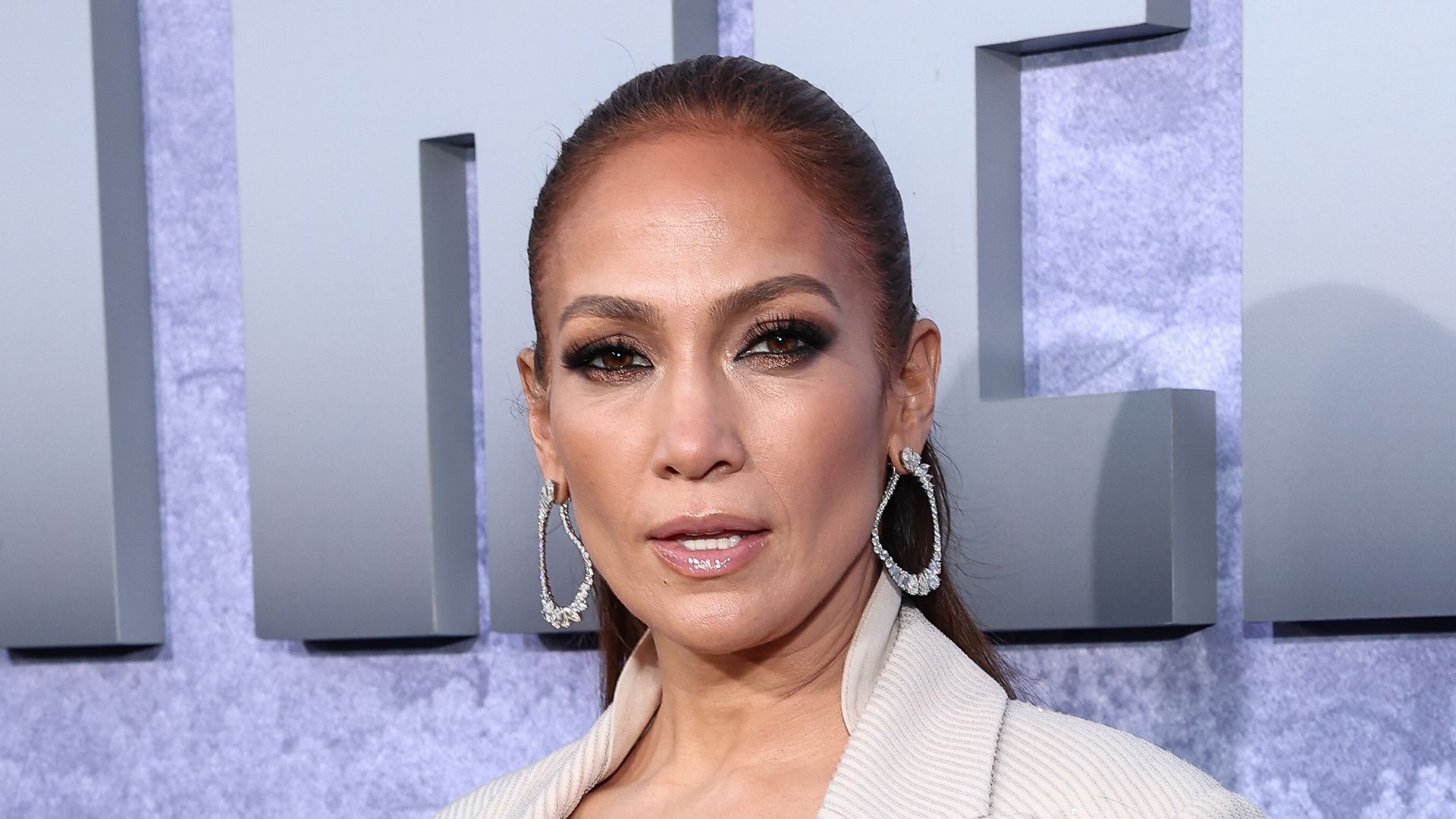 Jennifer Lopez at the premiere of "The Mother" wearing a blazer and a bra underneath 