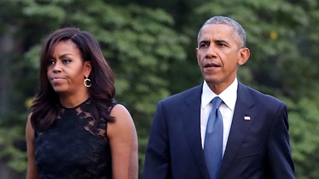 U.S. President Barack Obama (R) and first lady Michelle Obama walk across the South Lawn after returning to the White House on Marine One July 12, 2016 in Washington, DC. The Obamas were returning from Dallas where they attended a public memorial service for the five Dallas police officers who were killed by a sniper last week during a Black Lives Matter demonstration.  (Photo by Chip Somodevilla/Getty Images)