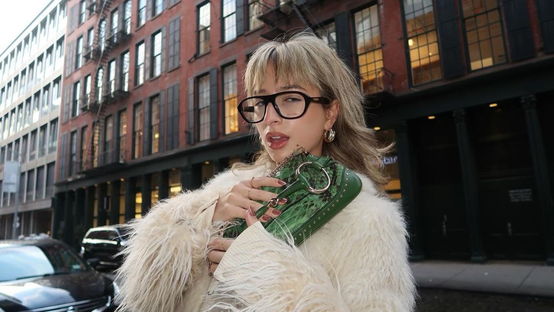 Influencer @izzipoopi poses with her green Gucci bag and transparent glasses in NYC