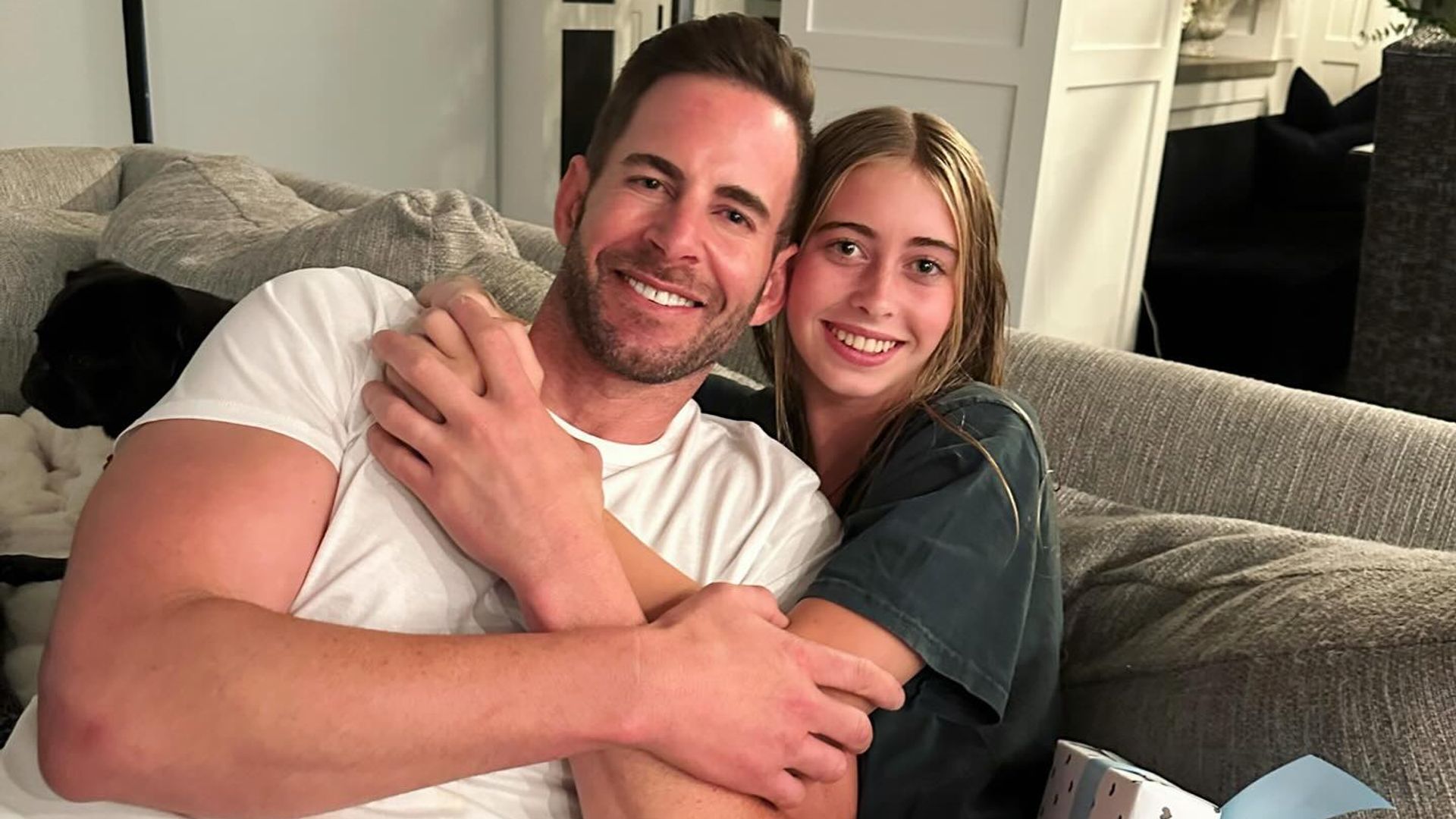 tarek el moussa and daughter taylor hugging on a couch