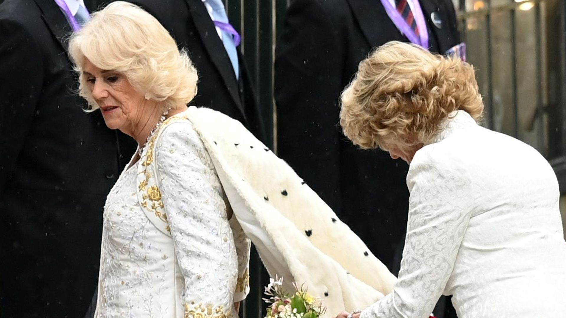 Queen Camilla's lady in attendance fixes her dress ahead of the coronation at Westminster Abbey