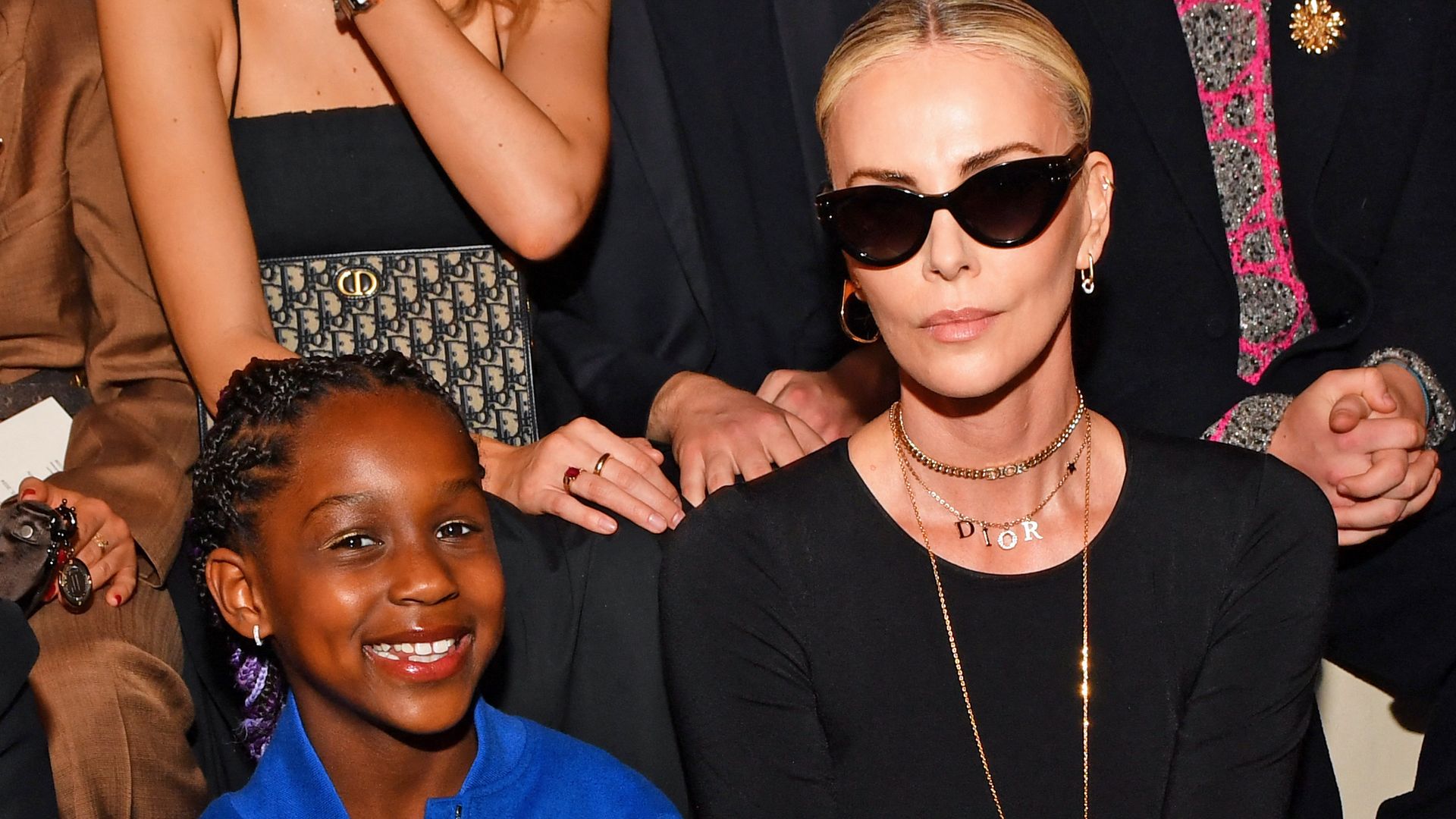 charlize theron sitting front row of fashion show with daughter