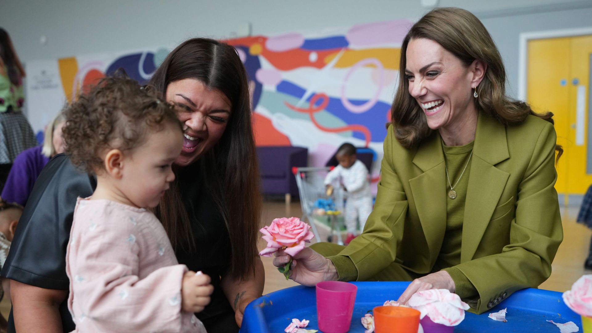 Kate holding a flower and laughing at little girl
