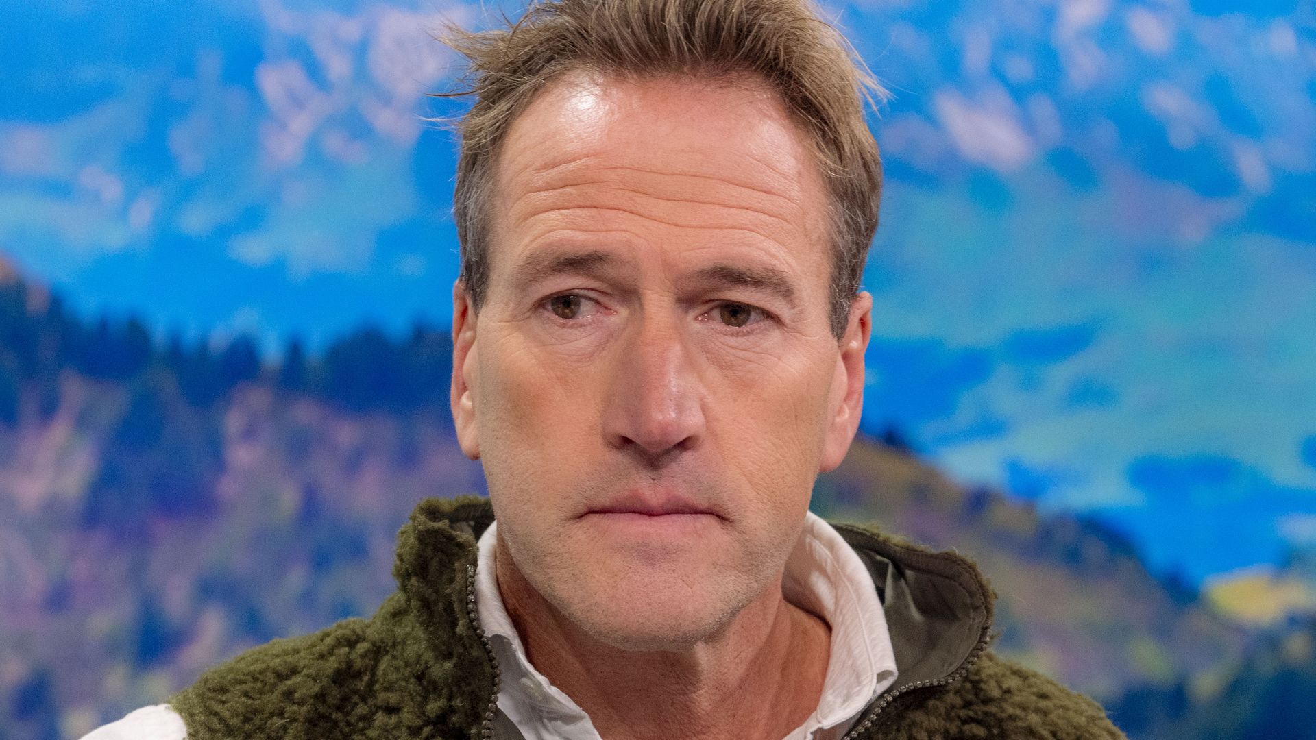 Ben Fogle frowning in a green gilet and white shirt