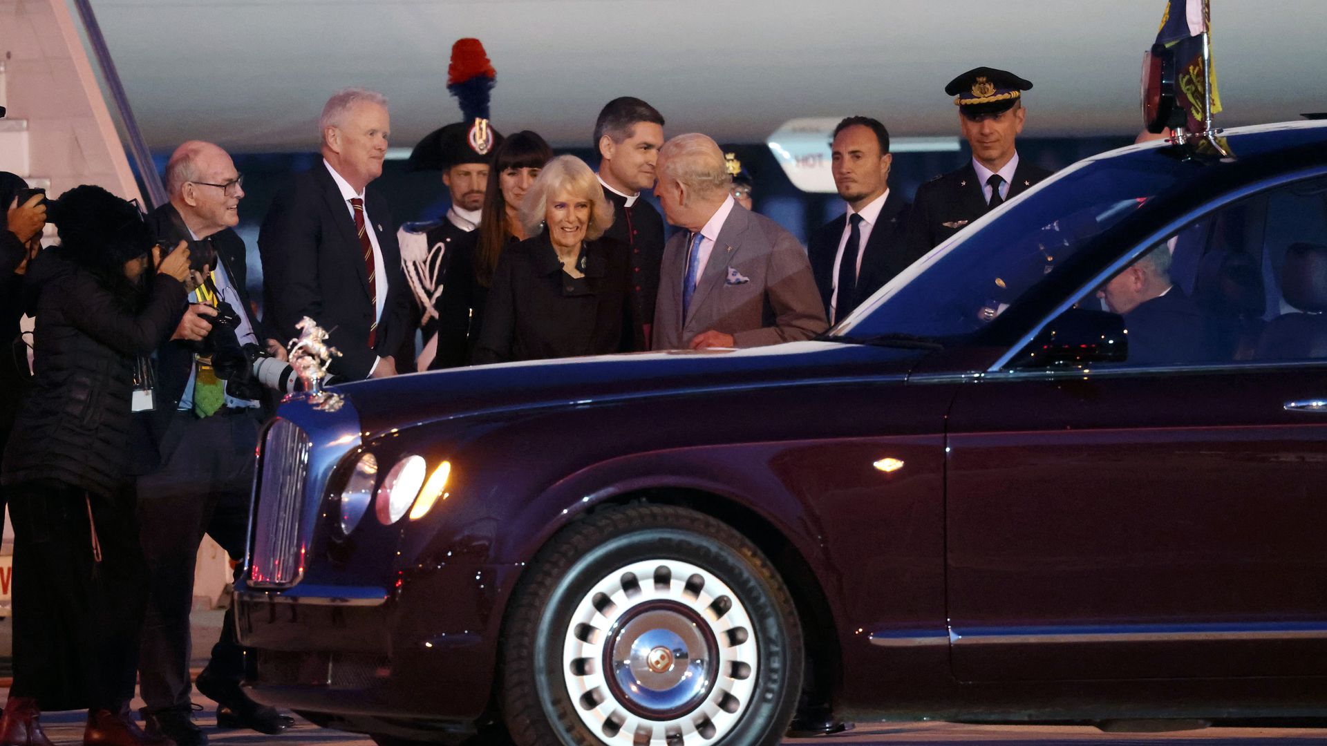 Queen Camilla and King Charles by a car