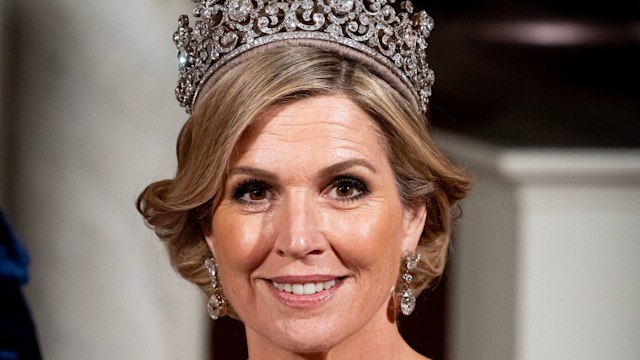 Queen Maxima smiling in blue gown and tiara