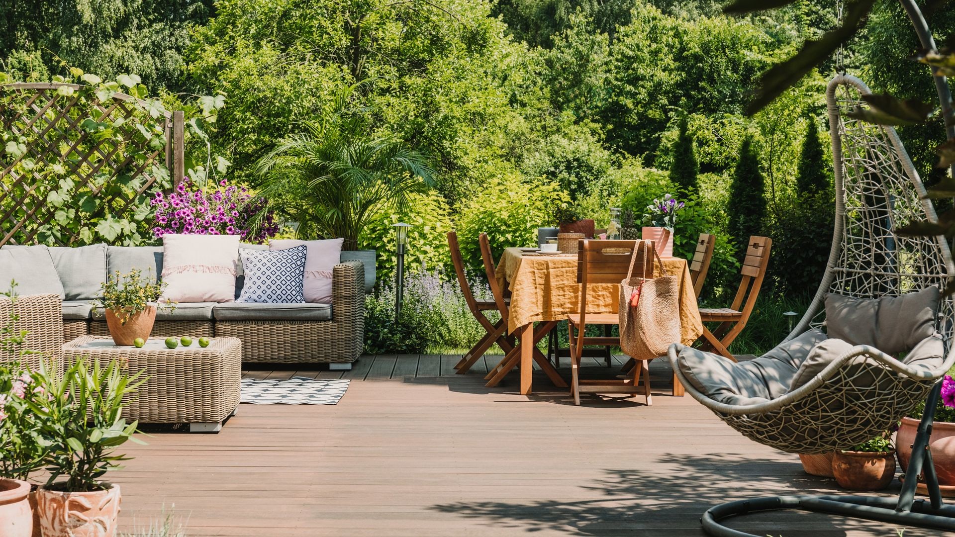 A garden deck with outdoor sofa and dining table