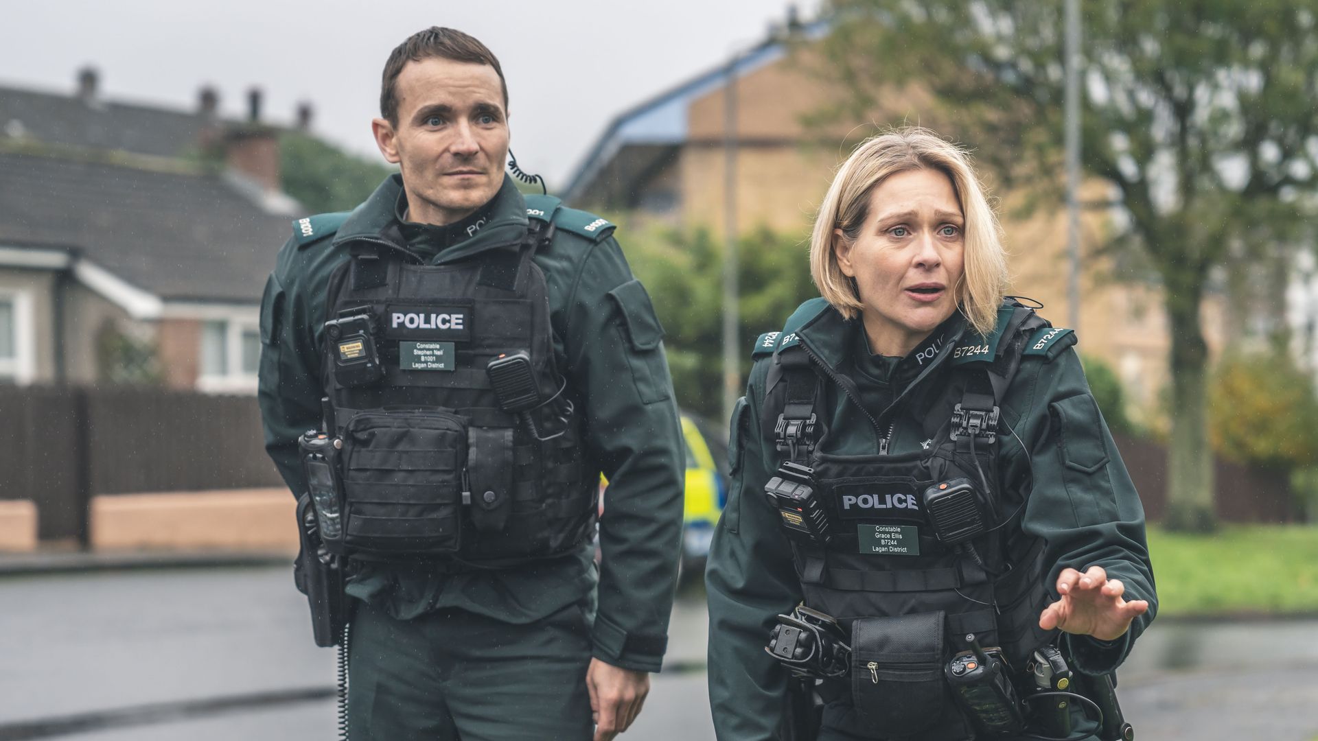 male and female police officer standing in street