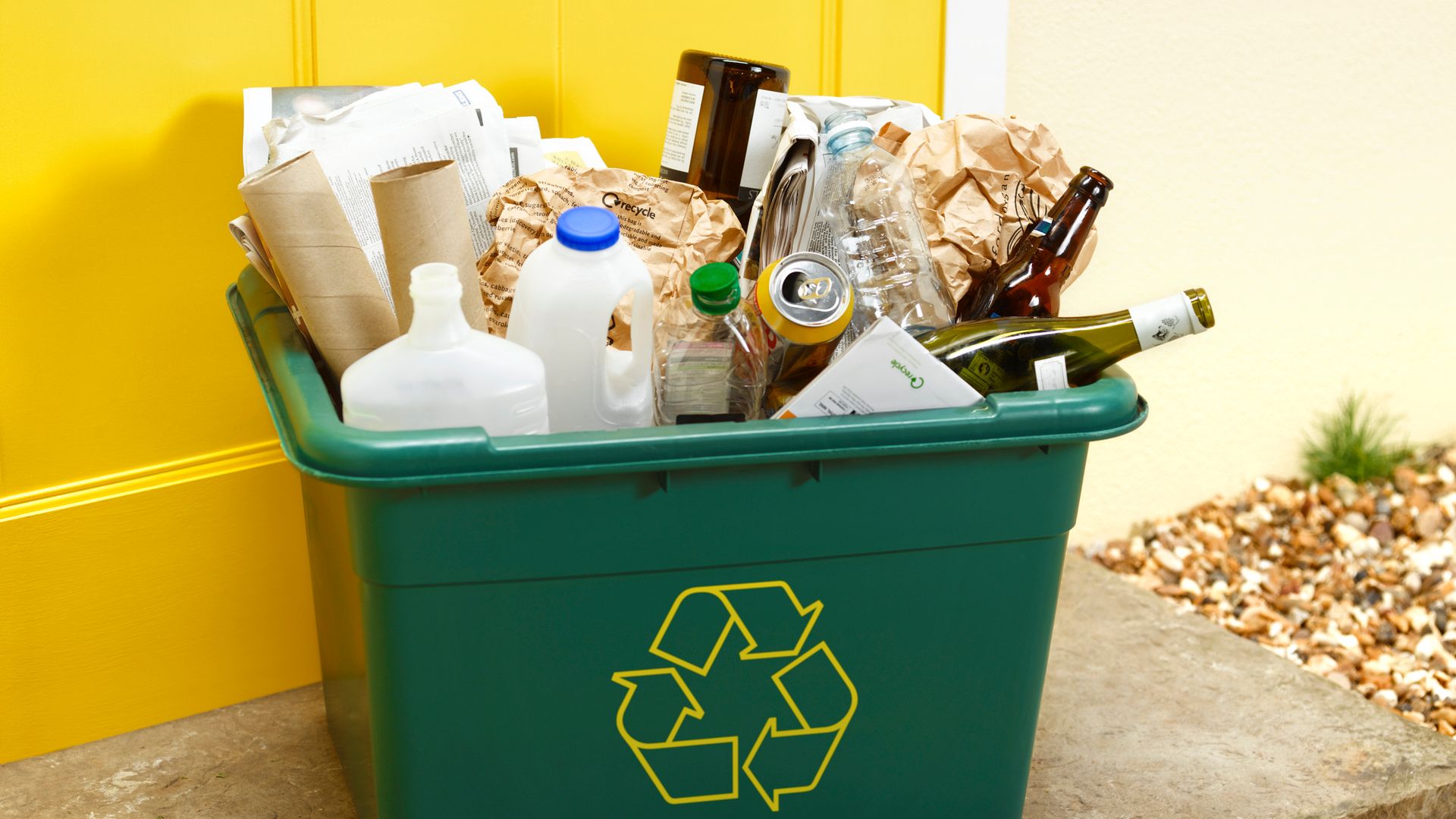 A recycling box with plastic bottles, glass bottles and cardboard
