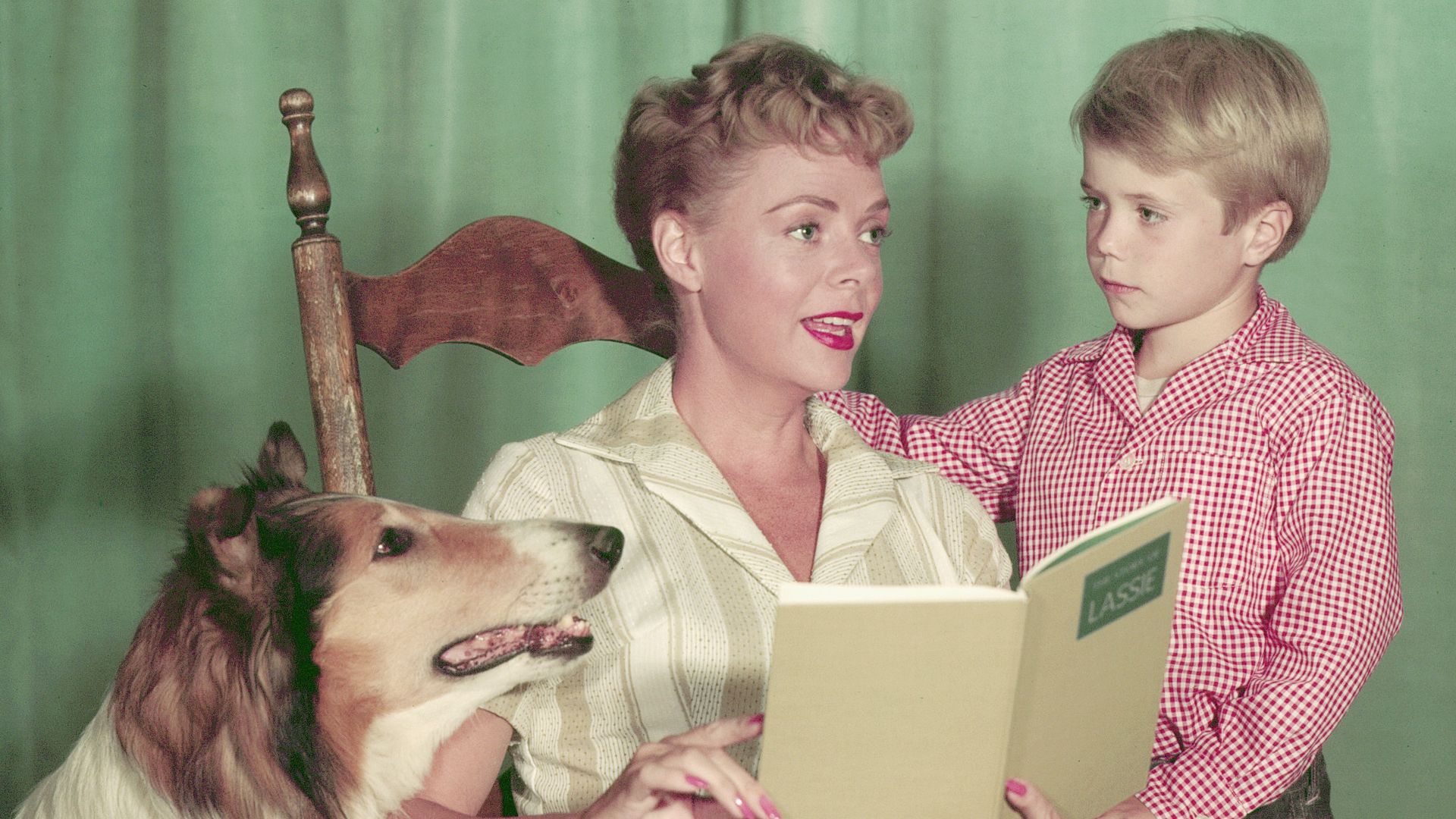 Promotional portrait of American animal actor Baby, as Lassie, actress June Lockhart, as Ruth Martin, and Jon Provost, as Timmy, as they read the book 'Lassie' for the television series of the same name, 1960