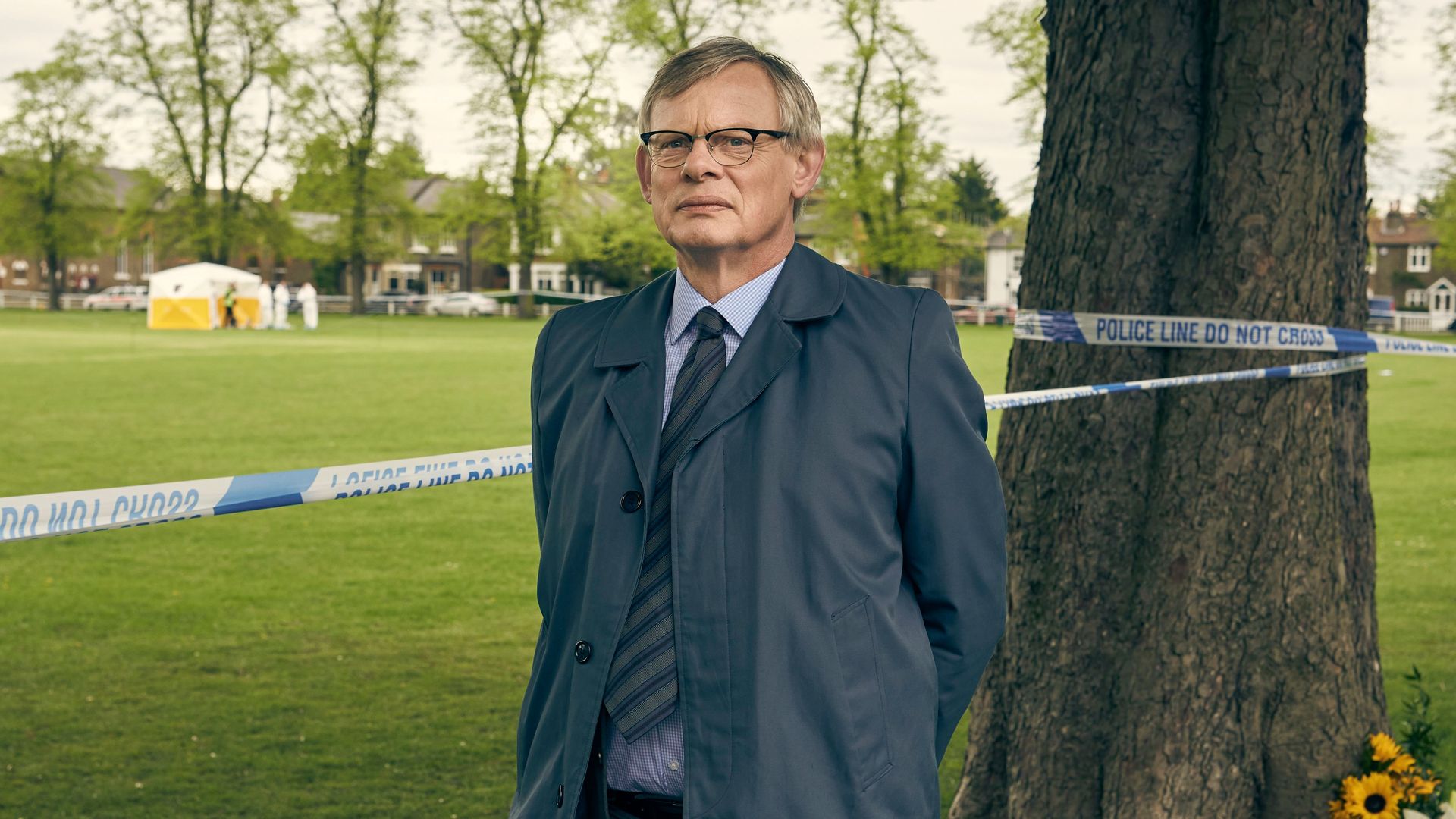 police detective standing by police tap in field