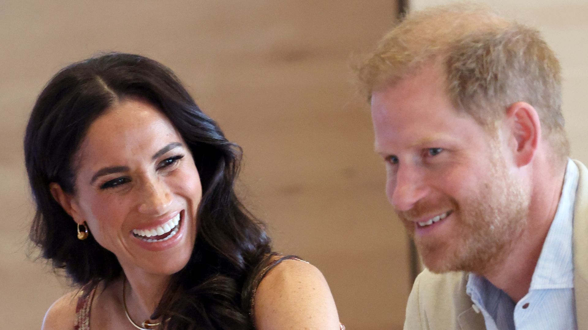 Meghan, Duchess of Sussex laughing looking at Prince Harry who looks unsure