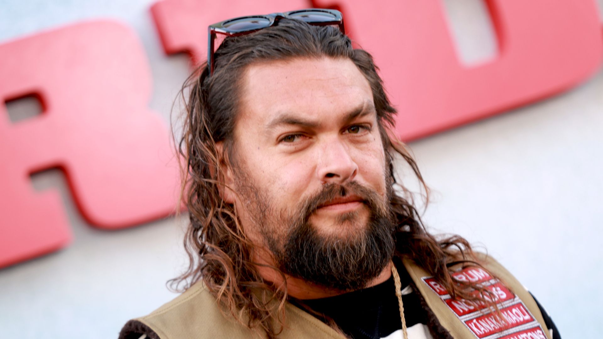 jason momoa with glasses on head on red carpet