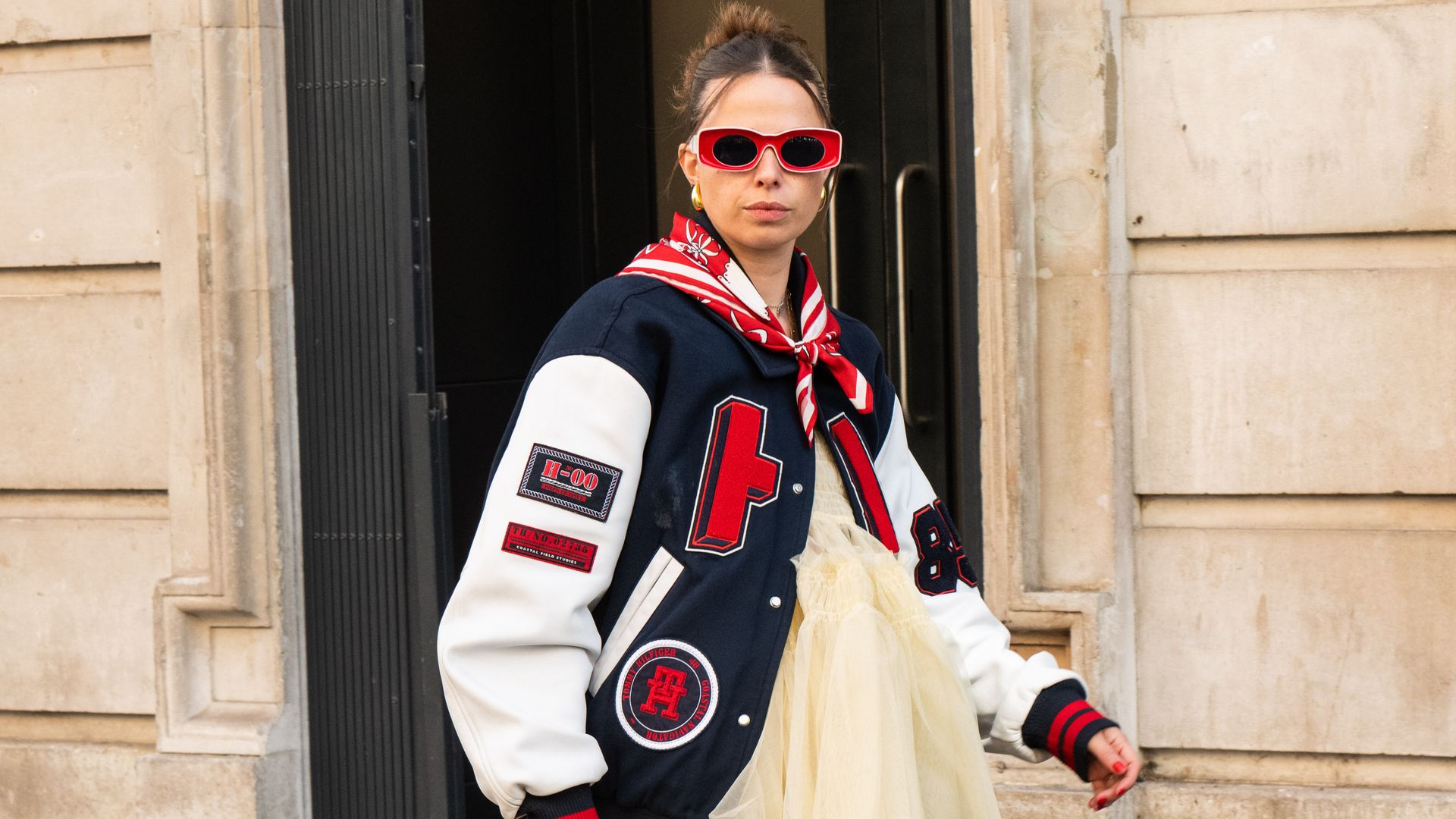 Orion Scott wears a Molly Goddard dress, Tommy Hilfiger jacket, Moon boots, vintage sunglasses and scarf outside the Bora Aksu show during London Fashion Week September 2024 
