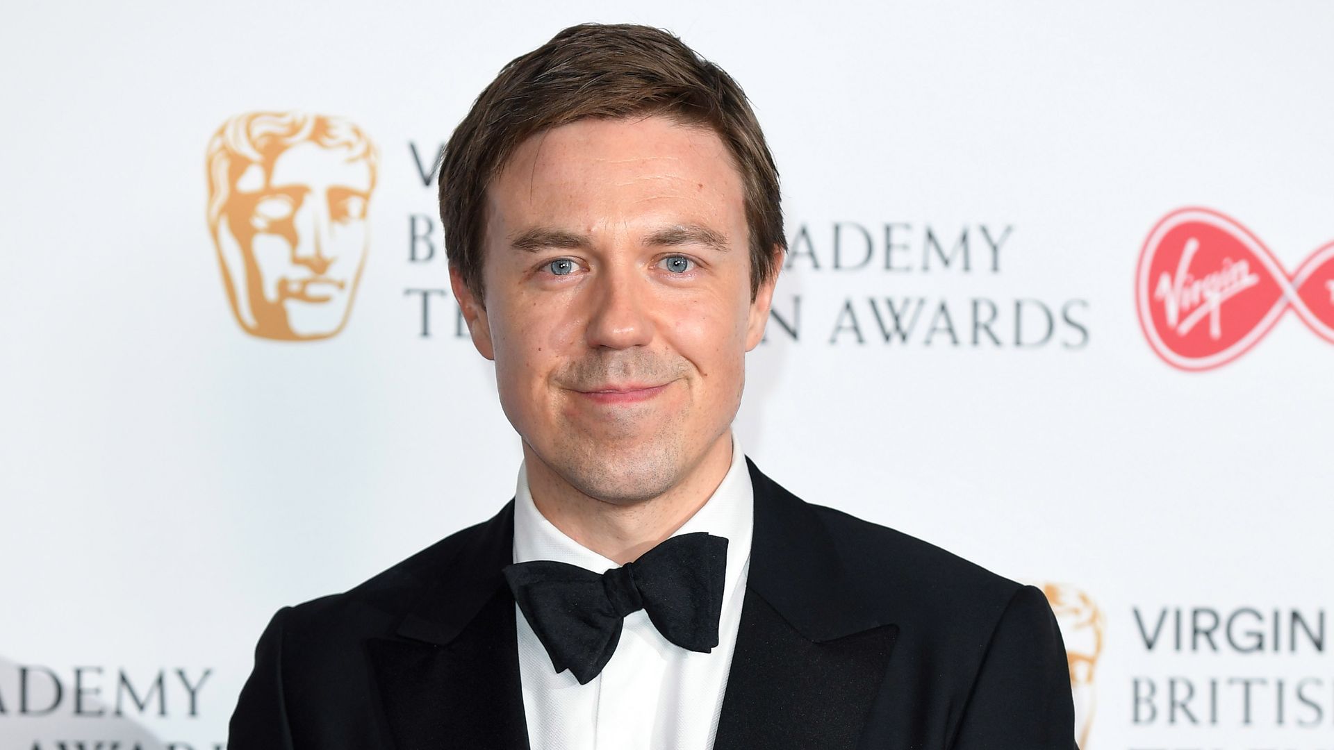 Andrew Buchan wearing a black tuxedo