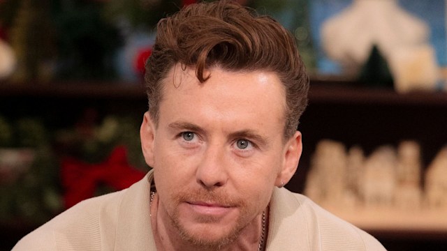 danny jones sitting on blue sofa 