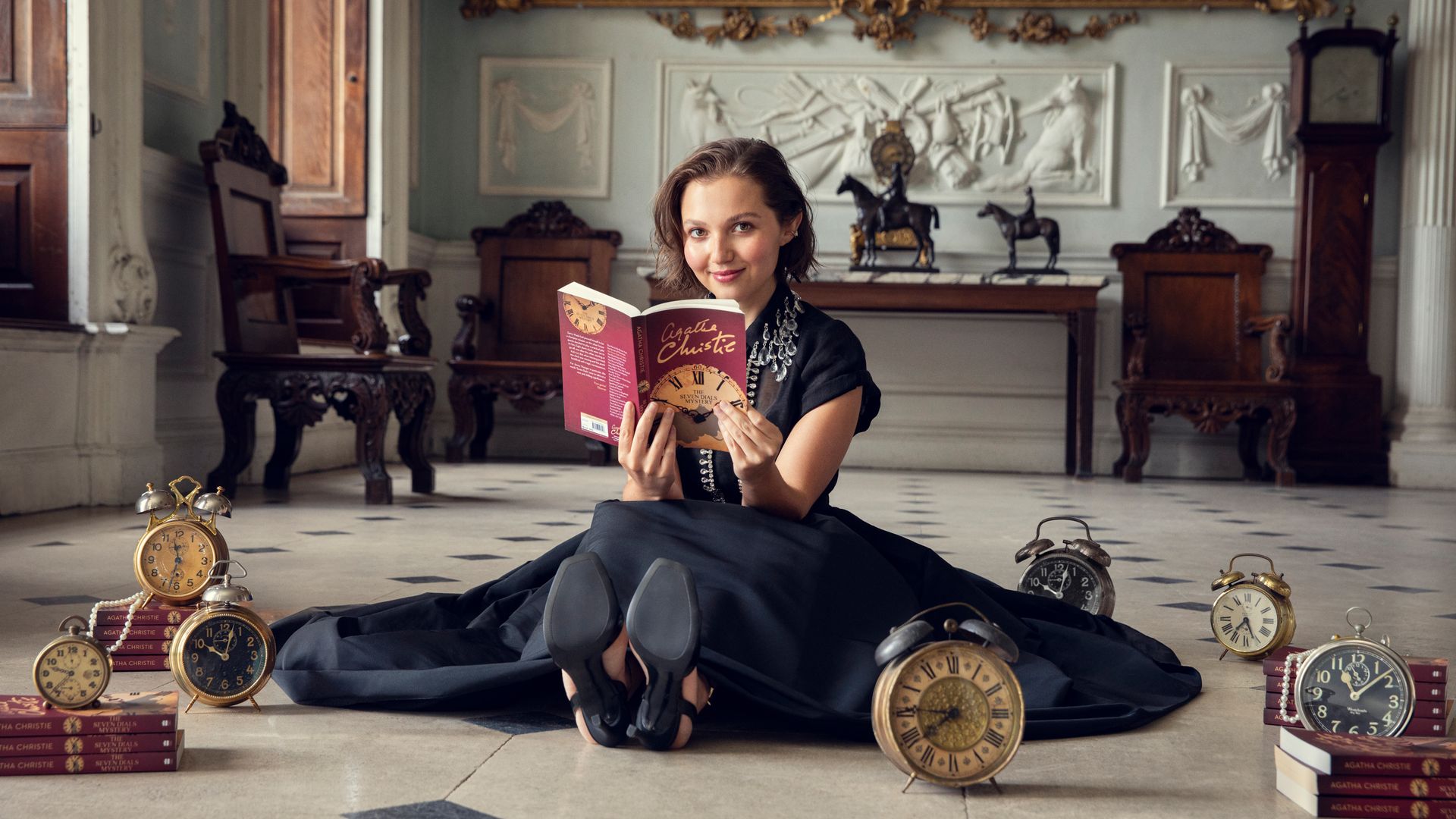 Young woman sitting on the floor holding a book