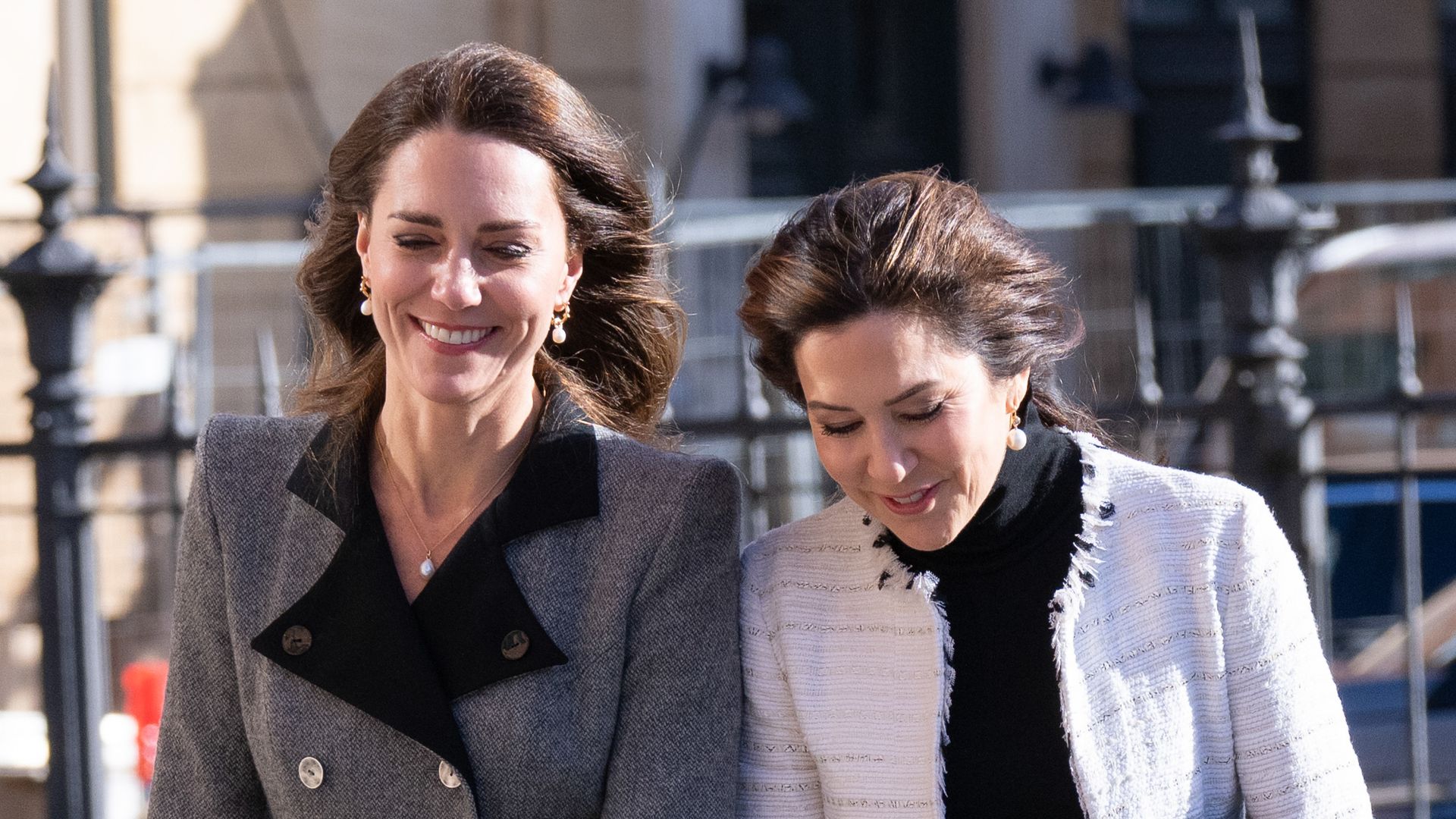 Queen Mary and Princess Kate walking in denmark in the wind smiling as their hair is blown about