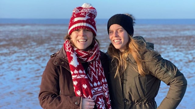 Princesses Eugenie and Beatrice smiling on a beach during the winter